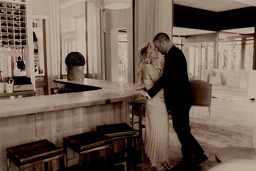 Warm toned black and white photo of couple romantically gazing into each other's eyes in Print Works Bistro.
